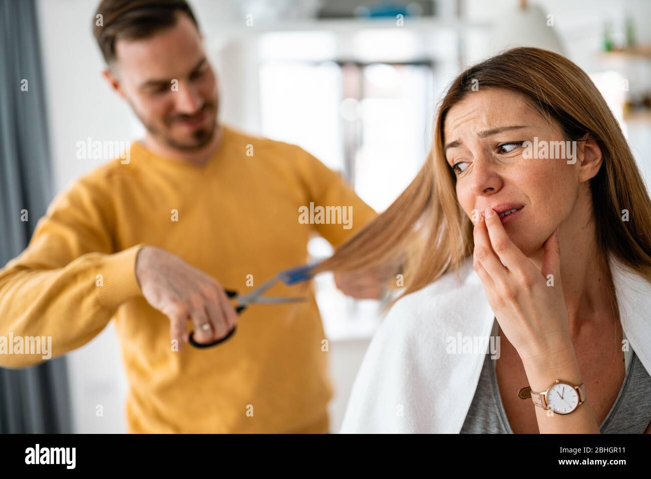 L'uomo fa un taglio di capelli alla donna a casa durante la quarantena. Foto Stock