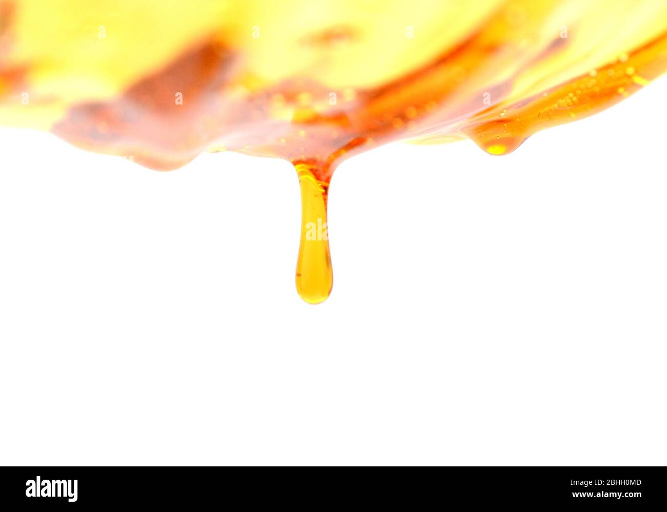 Il miele che scorre su sfondo bianco Foto Stock