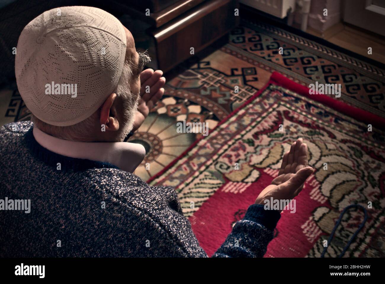 Un uomo musulmano turco molto vecchio, con un cappuccio di preghiera, che prega Allah a casa sua, durante la sua preghiera nel mese di Ramadan Foto Stock