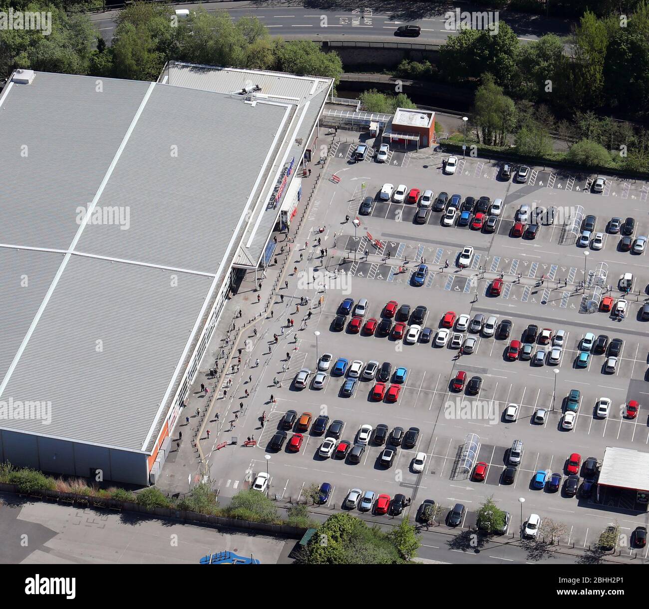 Vista aerea di un supermercato (Tesco Extra, Wigan) che mostra la coda con 2m di distanza sociale a causa della pandemia Covid-19 Foto Stock