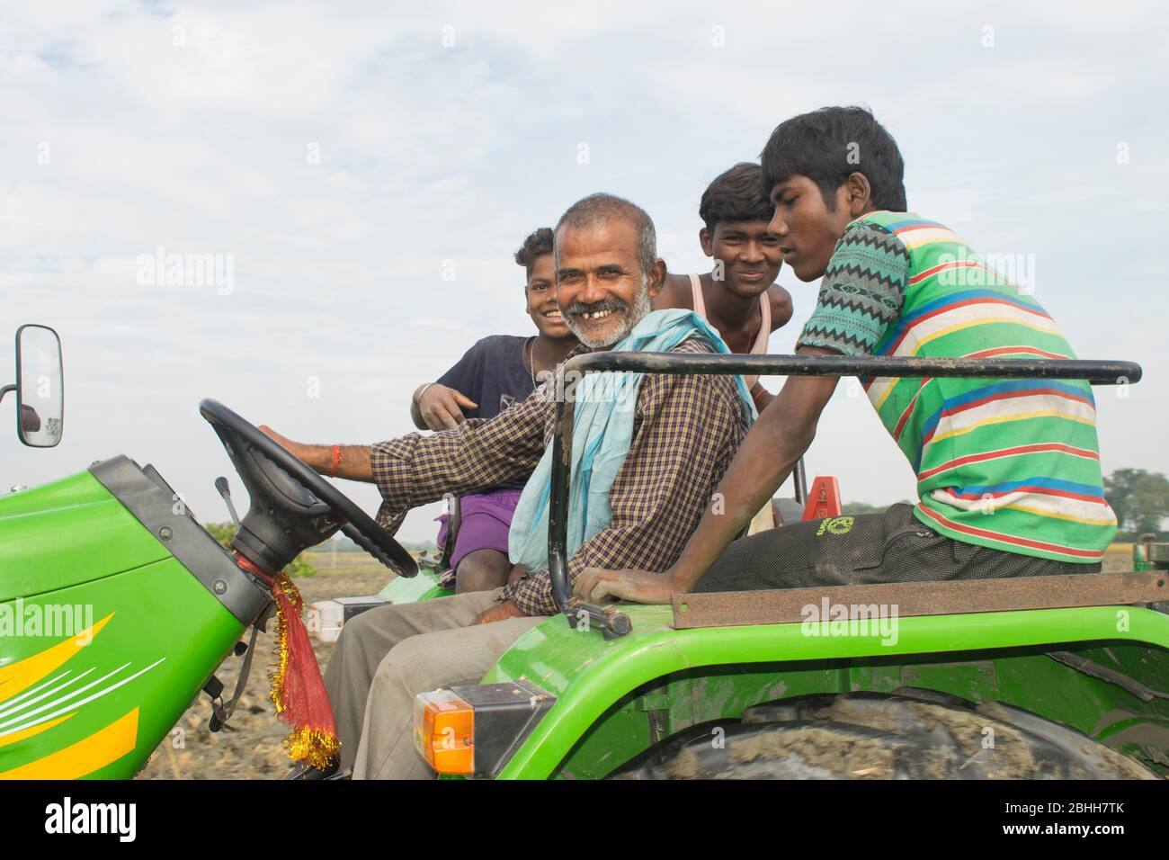 felice agricoltore su trattore con la sua famiglia Foto Stock