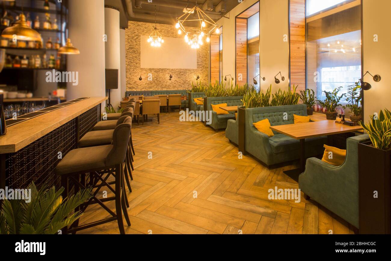 Interni moderni del ristorante con tavoli e divani e banco bar Foto Stock