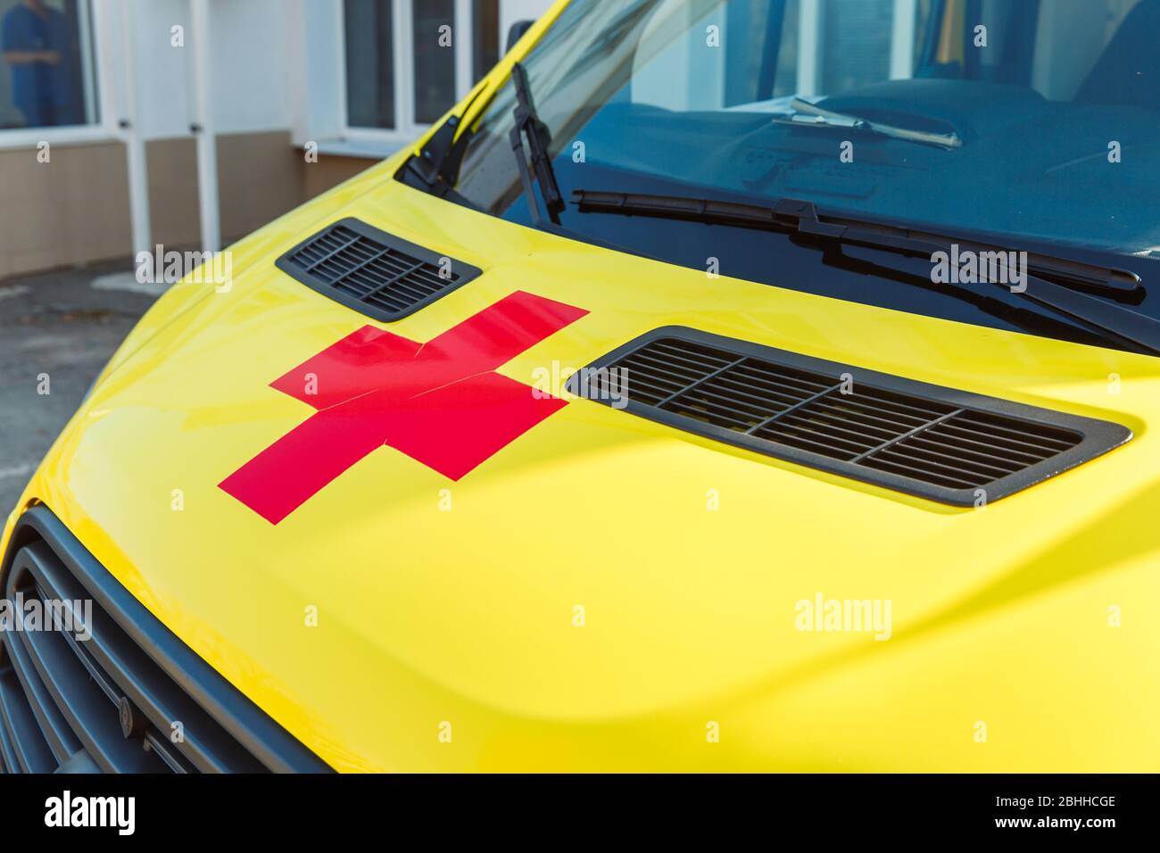 La croce rossa sul cappuccio giallo del concetto di ambulanza.Medicina e sanità. Foto Stock