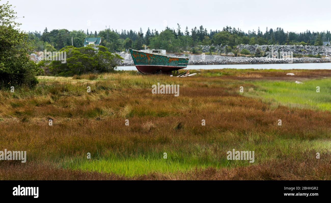 Un vecchio peschereccio è abbandonato e marciando sull'erba sull'isola di Vinalhaven nel Maine. Foto Stock