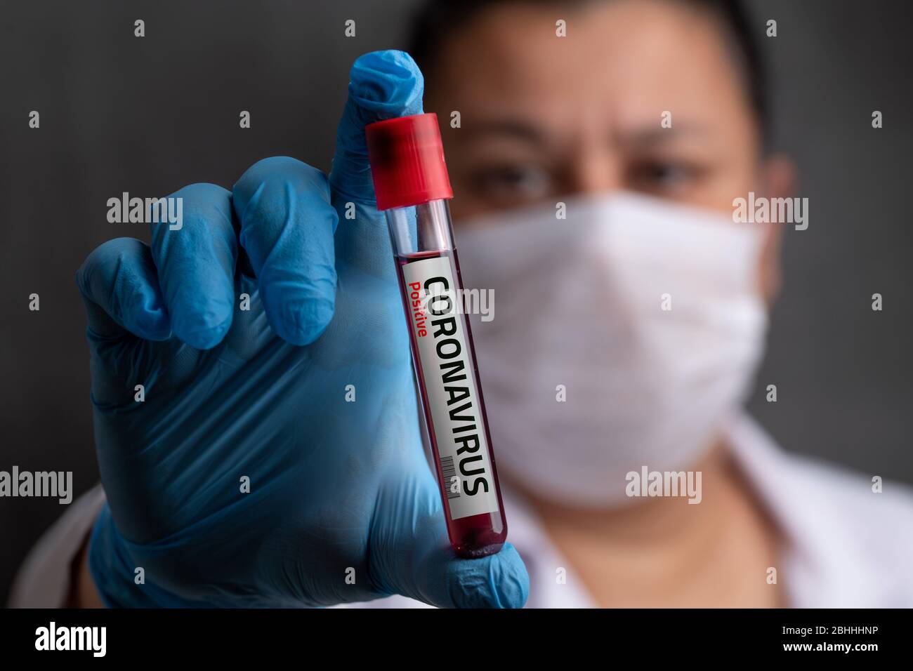 Infermiere che indossa una maschera respiratoria con un risultato positivo dell'analisi del sangue per il coronavirus Foto Stock