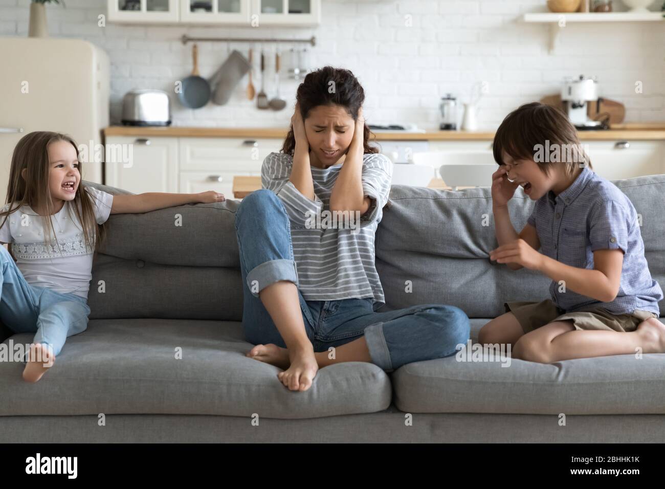 Stressato giovane mummia irritato da cattivi ragazzi fratelli comportamento. Foto Stock