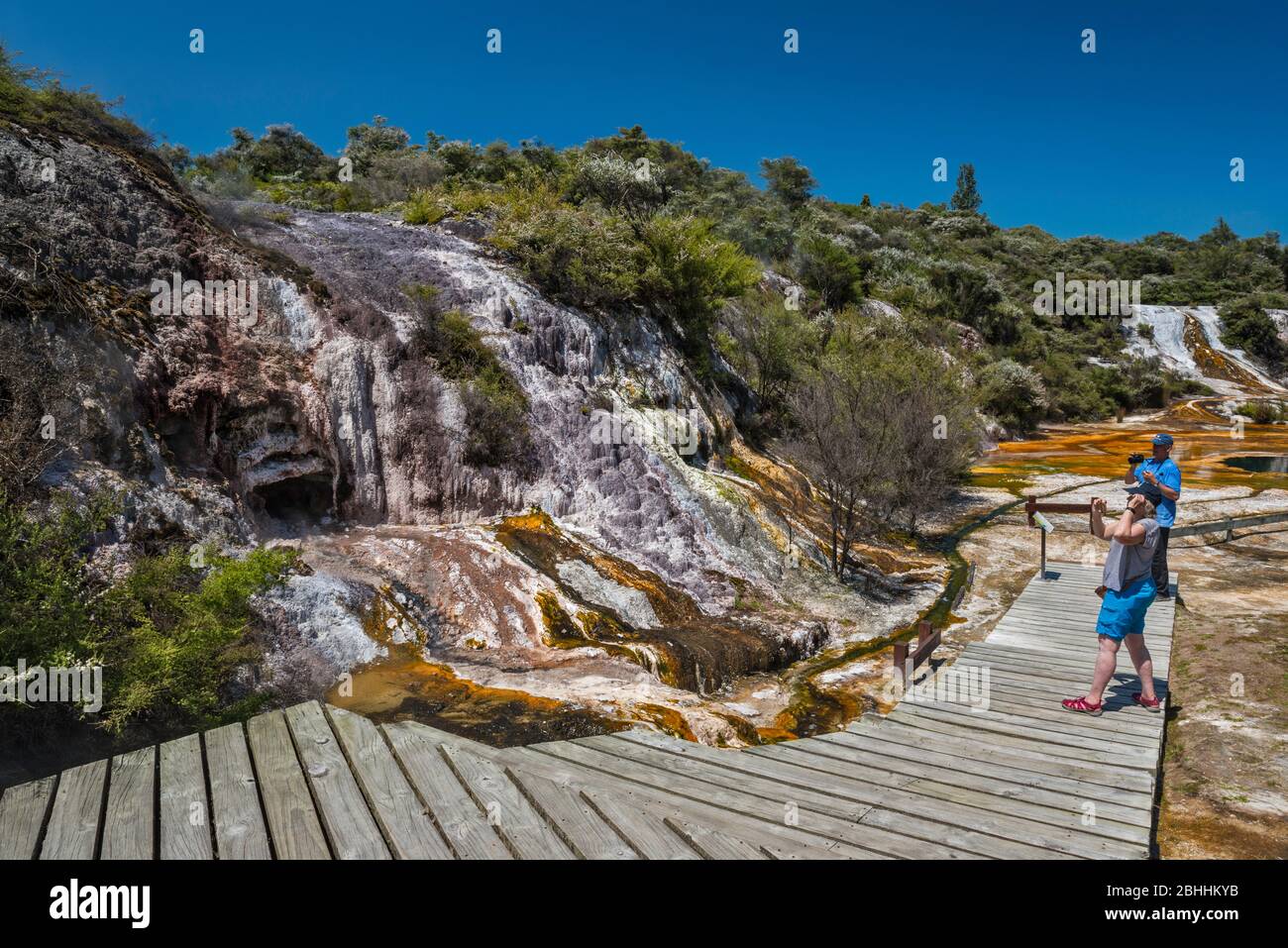 Turisti a Rainbow Terrace (terrazza sinter), Parco Termale Orakei Korako, zona vulcanica Taupo, Regione Waikato, Isola del Nord, Nuova Zelanda Foto Stock