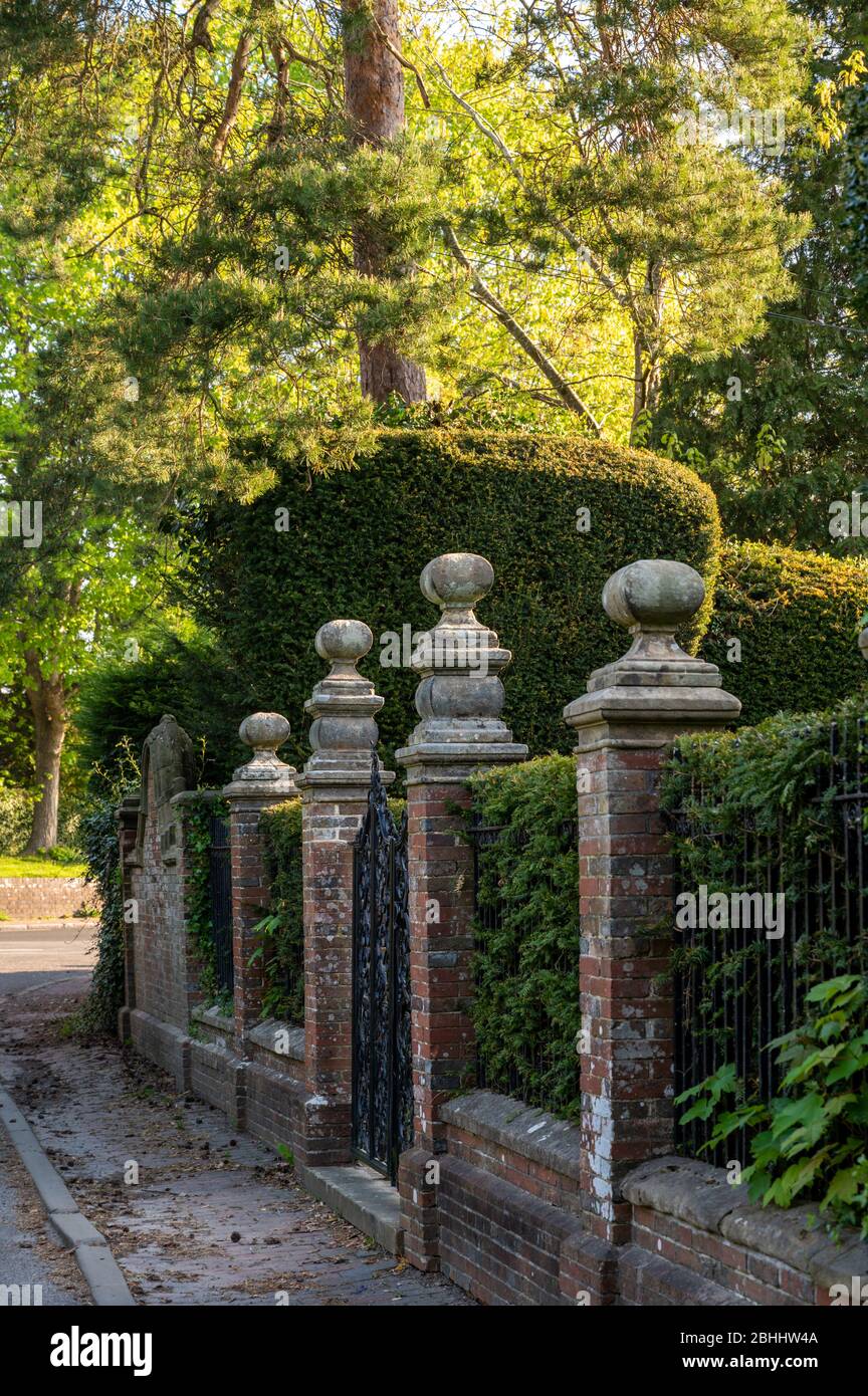 Muro di mattoni e recinzione in ferro battuto che separano Old Place da Francis Road nella parte nord dello storico villaggio di Lindfield, West Sussex, Regno Unito. Foto Stock