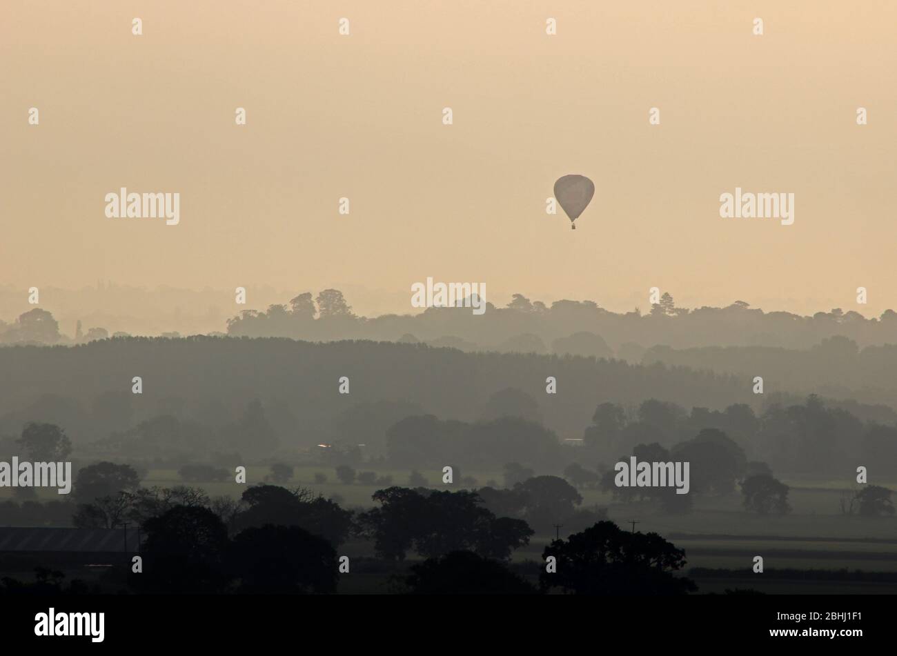 Mongolfiera che viaggia attraverso le pianure del Cheshire visto da Borras Head, Wrexham Foto Stock