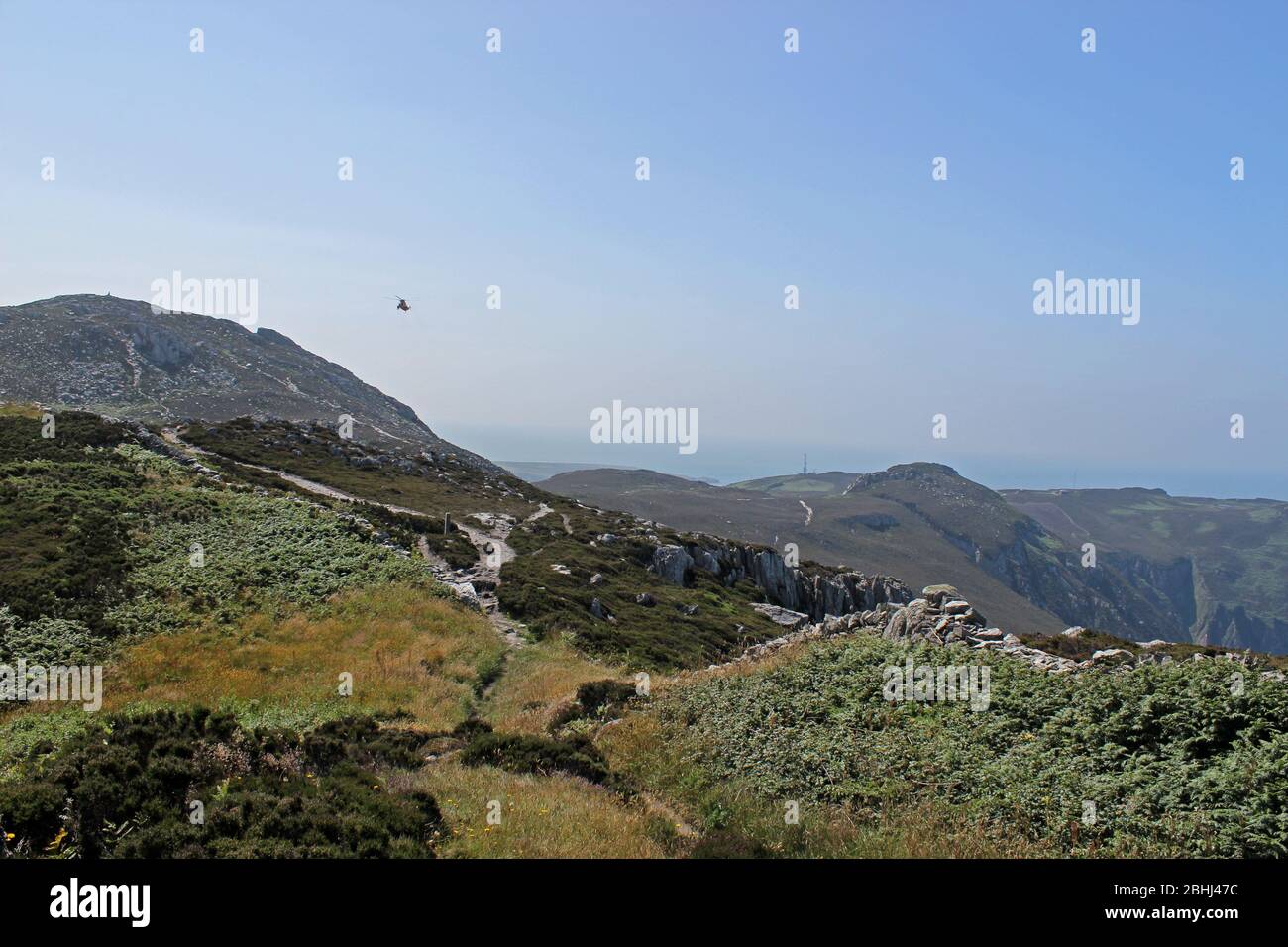 RAF elicottero di salvataggio che pratica manovre sopra Holyhead montagna, Anglesey, Galles Foto Stock