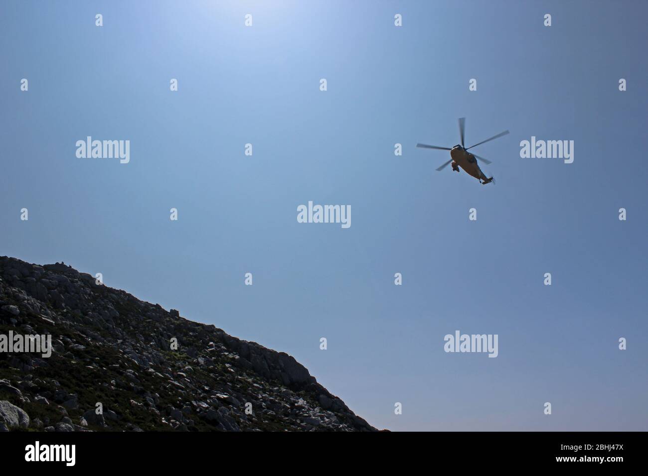 RAF elicottero di salvataggio che pratica manovre sopra Holyhead montagna, Anglesey, Galles Foto Stock