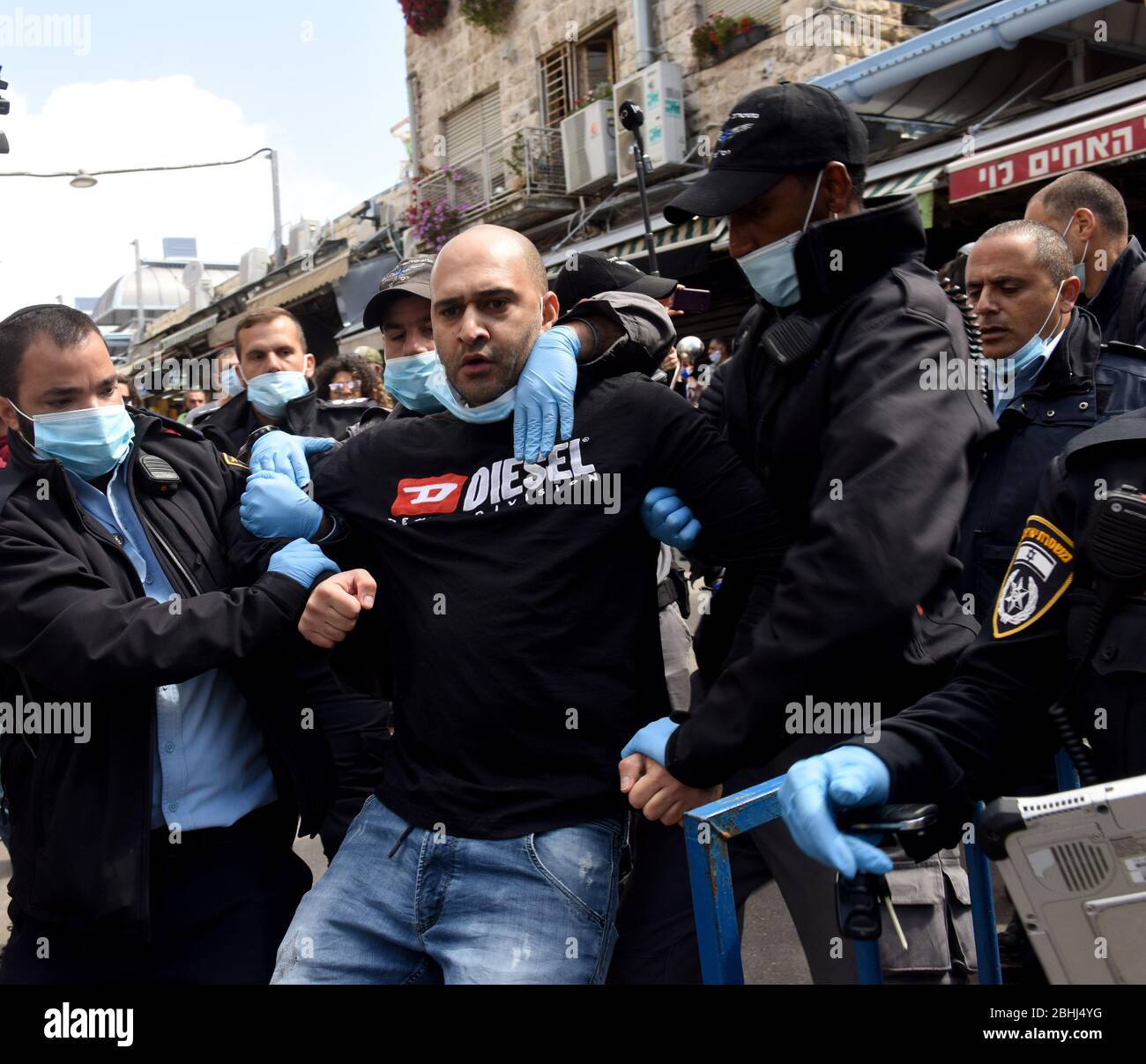 Gerusalemme, Israele. 26 aprile 2020. La polizia israeliana arresta un venditore del famoso mercato all'aperto Mahane Yehuda, durante una protesta contro la chiusura estesa del mercato, mentre il governo israeliano ha allentato le restrizioni di coronavirus per altre imprese, lunedì 26 aprile, a Gerusalemme. I manifestanti hanno bandito i pans e gridato contro l'apertura di IKEA, mentre sono costretti a rimanere chiusi. Foto di Debbie Hill/UPI Credit: UPI/Alamy Live News Foto Stock