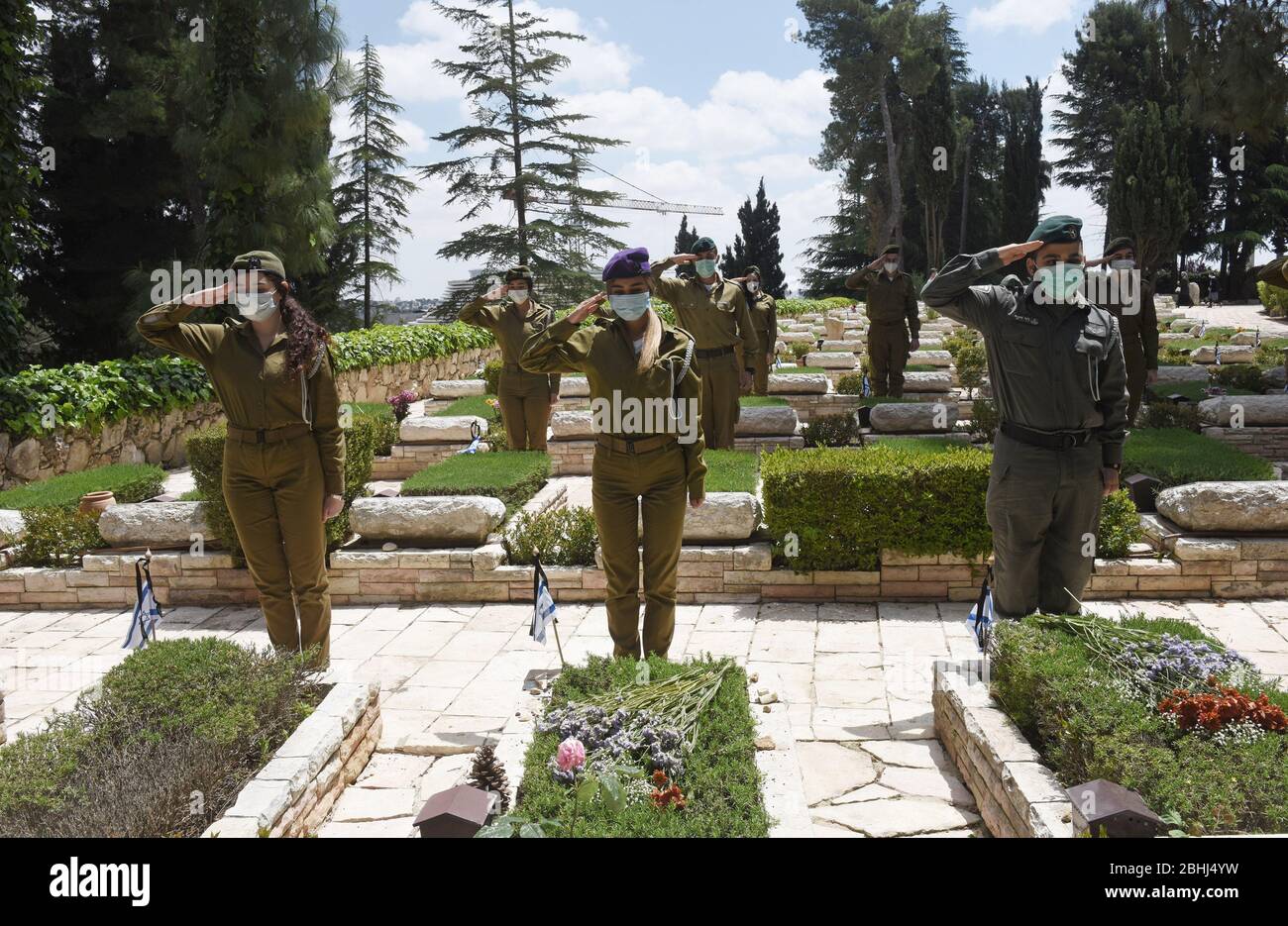 Gerusalemme, Israele. 26 aprile 2020. I soldati israeliani indossano maschere per la protezione contro il coronavirus, mentre salutano le tombe dei soldati caduti, prima del Memorial Day, nel Monte Herzl Cimitero militare, Domenica 26 aprile, a Gerusalemme. Alle famiglie ereaved sarà proibito visitare il cimitero nel giorno commemorativo di Israele per i soldati caduti e le vittime del terrore, che inizia al tramonto, il 27 aprile, nel tentativo di fermare la diffusione del COVID-19. Foto di Debbie Hill/UPI Credit: UPI/Alamy Live News Foto Stock