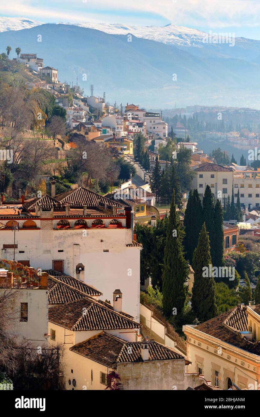 Paesaggio pittoresco paesaggio vista città di Granada località tetto cime di case residenziali e vista valle lontano per innevare le montagne della Sierra Nevada Foto Stock