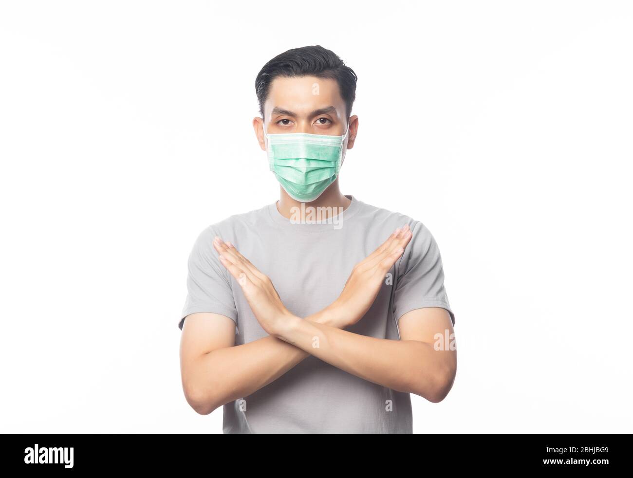 Giovane asiatico uomo che indossa la maschera igienica gesturing stop per prevenire le infezioni, 2019-nCoV o coronavirus. Malattie respiratorie trasmesse dall'aria come la lotta di pm 2.5 Foto Stock
