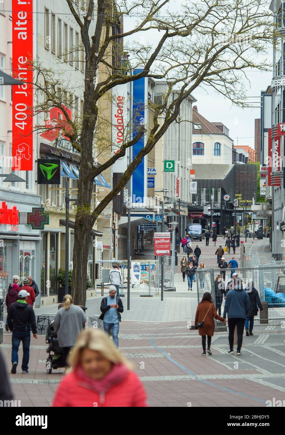 Kiel, Germania. 26 aprile 2020. La gente cammina attraverso i negozi chiusi  nel centro della città di Kiel attraverso Holstenstraße la domenica, quando  i negozi sono aperti per affari. Credit: Gregor Fischer/dpa/Alamy