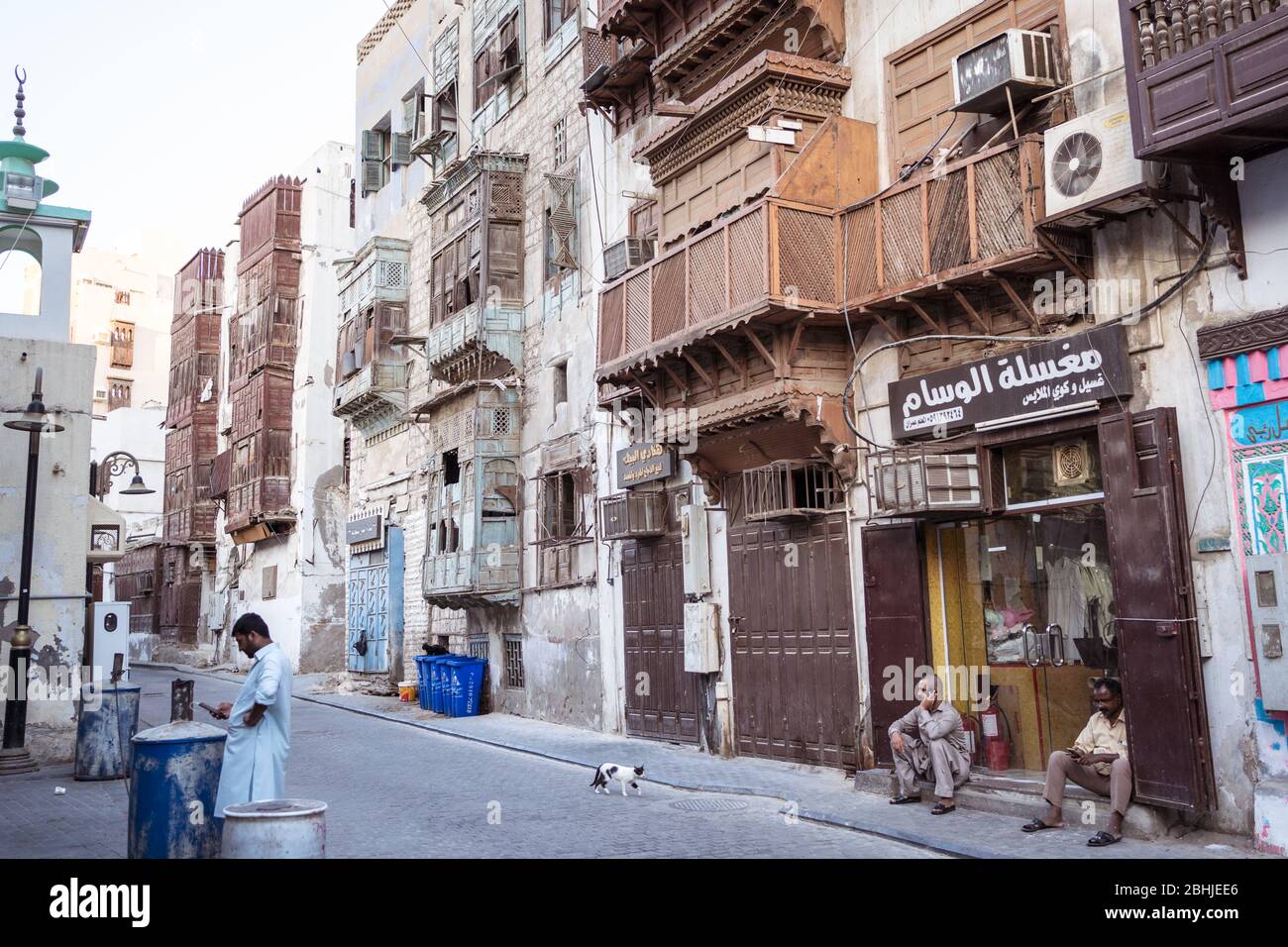 Jeddah / Arabia Saudita - 16 gennaio 2020: Due donne musulmane che indossano abaya e trasportano passeggino nel centro storico di al-Balad con edificio colorato sullo sfondo Foto Stock