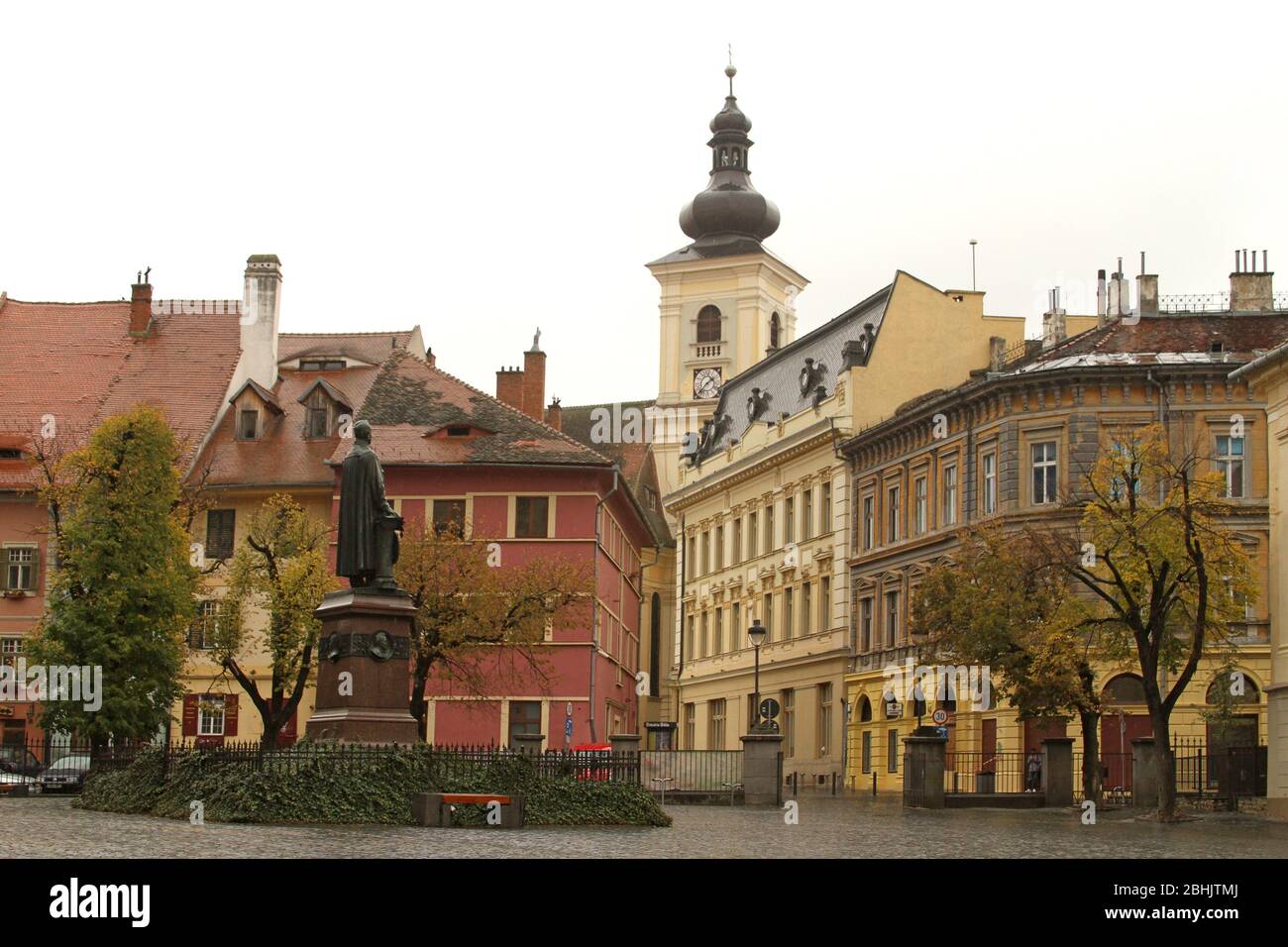 Sibiu, Romania. La statua del vescovo luterano G. D. Teutsch, del 1899, vista in Piazza Albert Huet. Santa Trinità Cattolica Romana Churh (indietro) Foto Stock