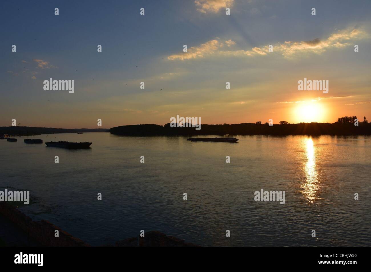 Traffico fluviale sul Danubio. Tramonto sullo sfondo Foto Stock