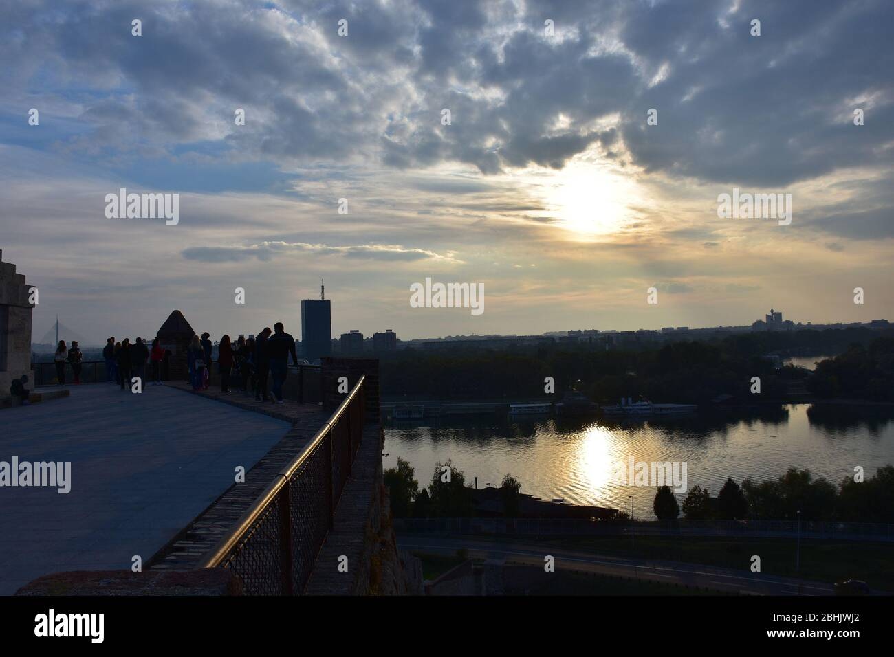 Molti escursionisti a Kalemegdan osservano il tramonto e il fiume Sava illuminato dal sole Foto Stock