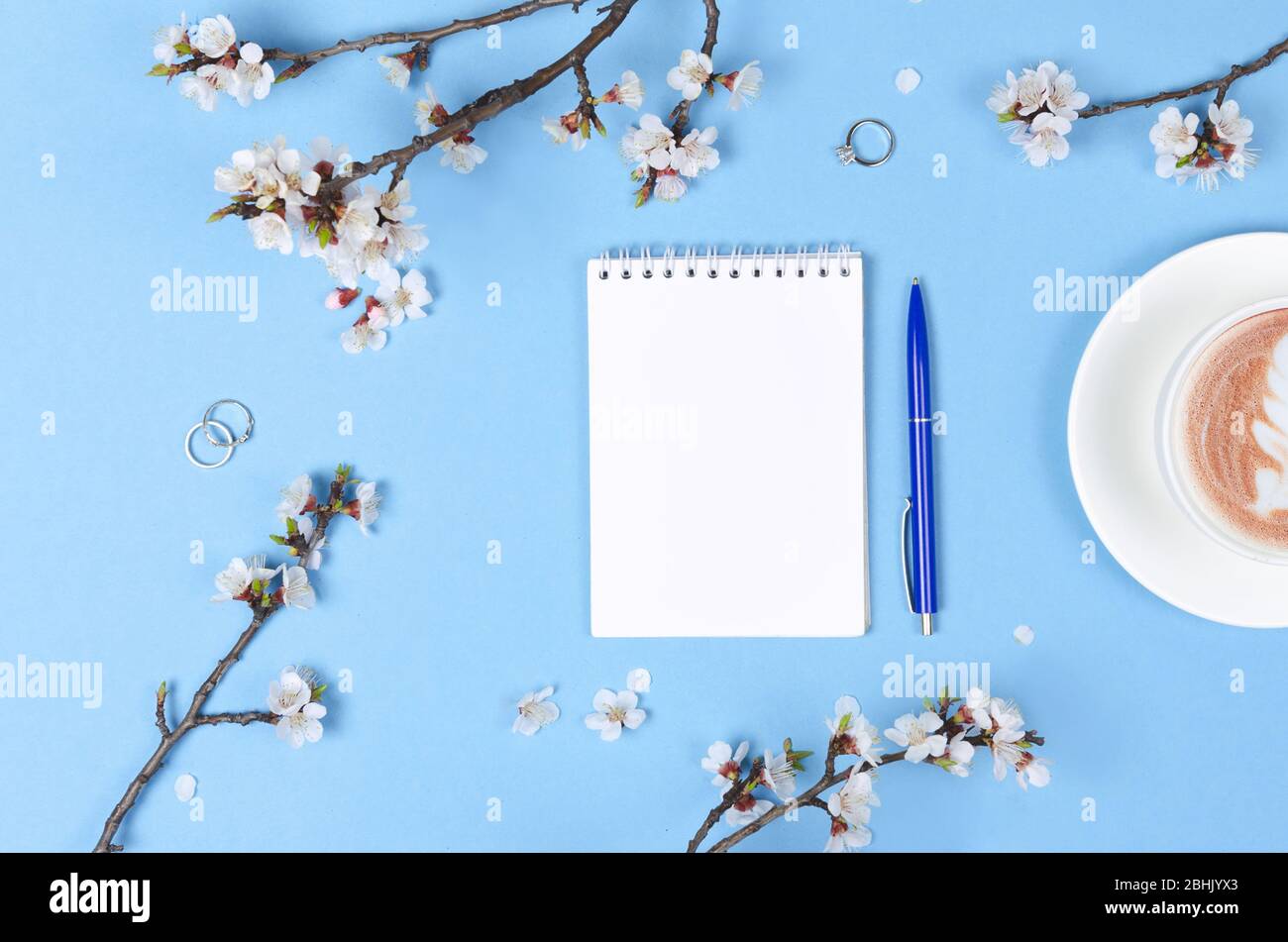 Lista dei desideri per i piani futuri. composizione piana con fiori e blocco note e caffè con latte art. Piano di nozze Foto Stock