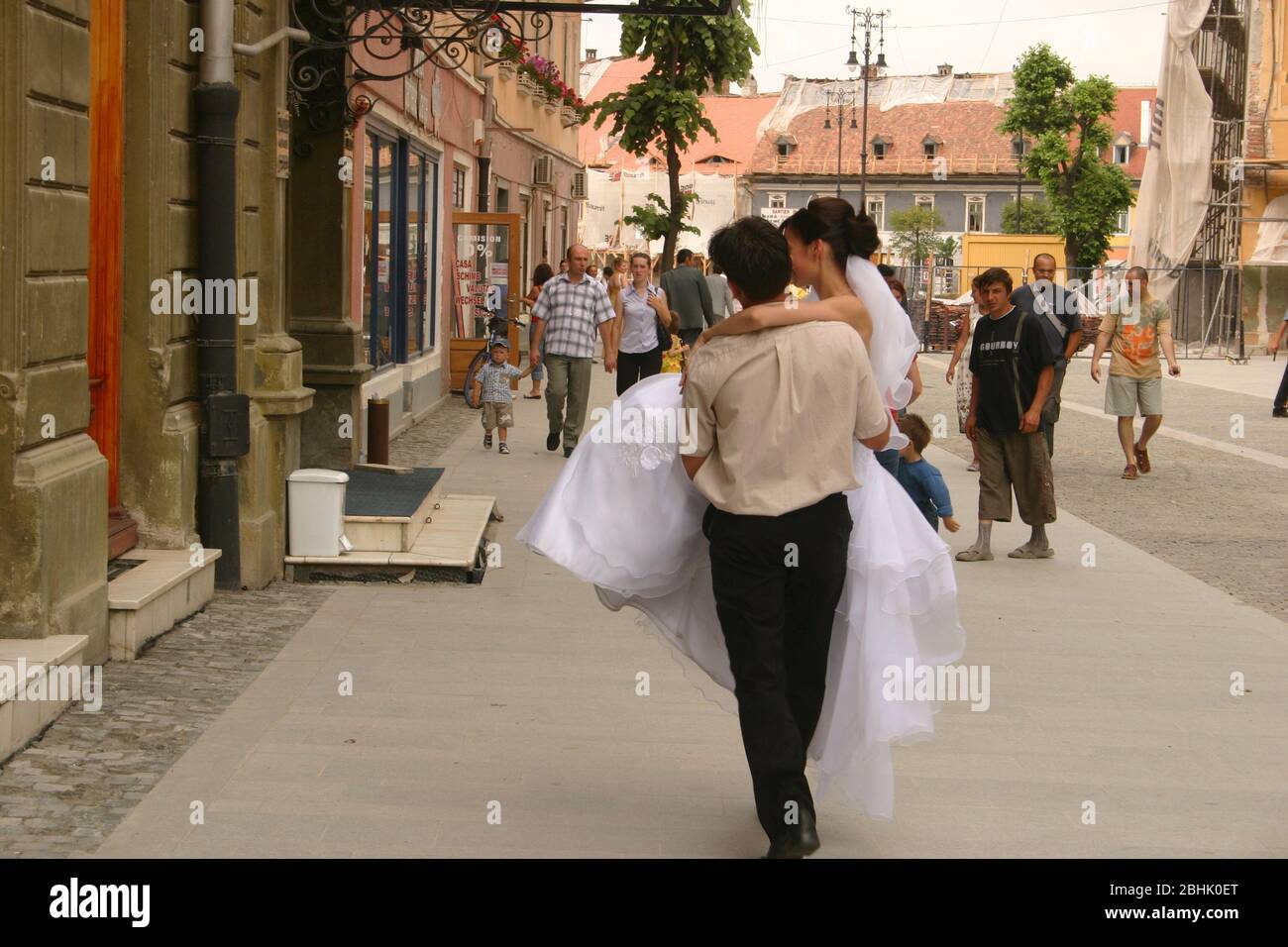 Sibiu, Romania. Vecchia abitudine di 'sceglare' la sposa durante il matrimonio in cambio di un compenso. Uomo che porta una sposa per le strade. Foto Stock