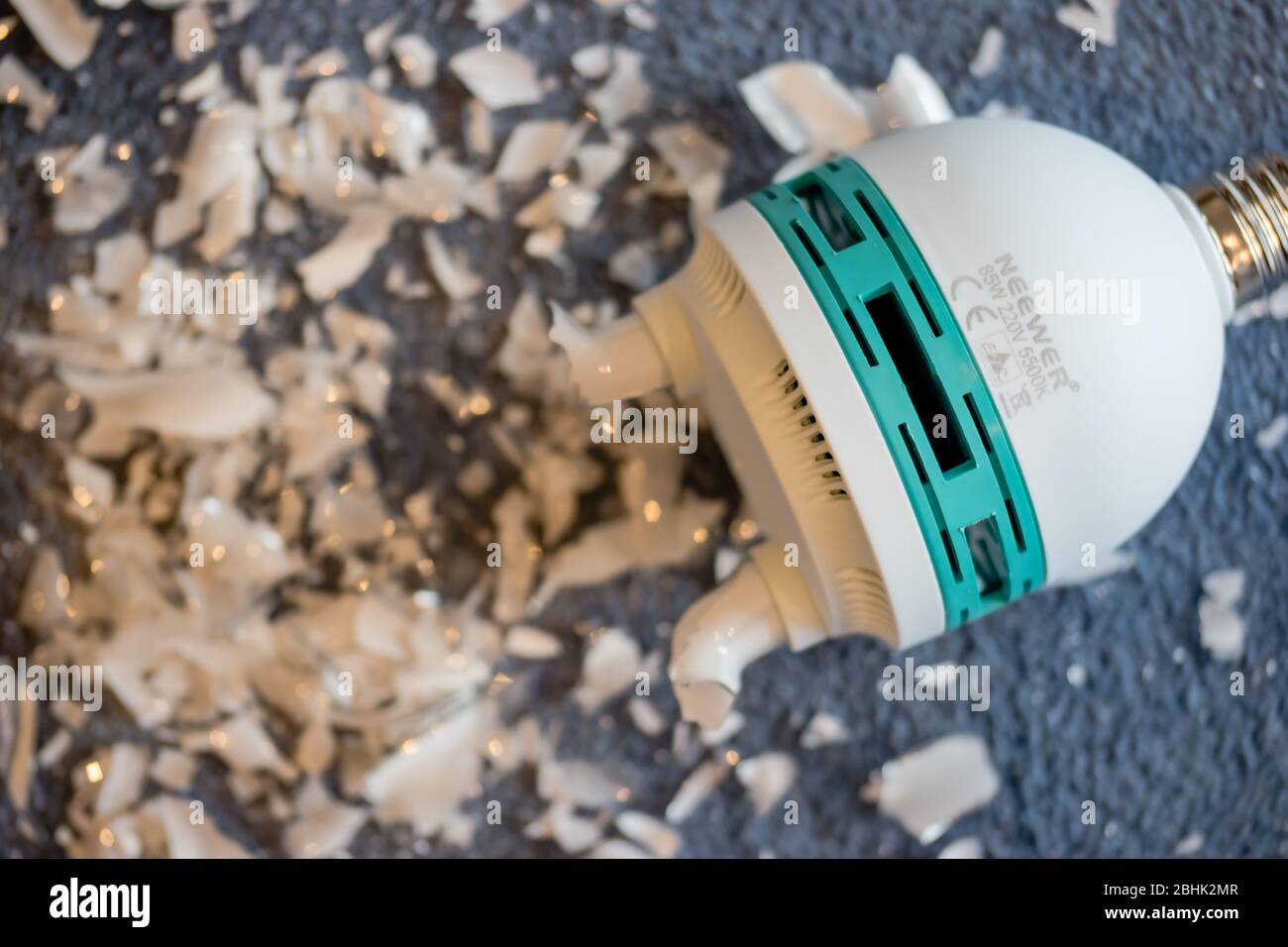 Una lampada da studio video frantumata - lampada fluorescente compatta o lampadina CFL - che ha rilasciato vapore di mercurio Foto Stock