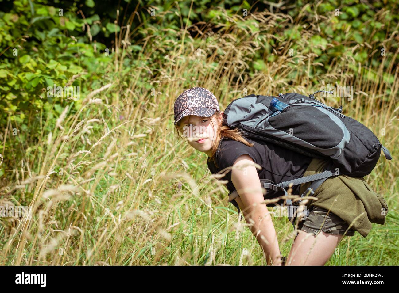 Adolescente ragazza esplorare la natura su una lunga escursione in campagna con zaino Foto Stock