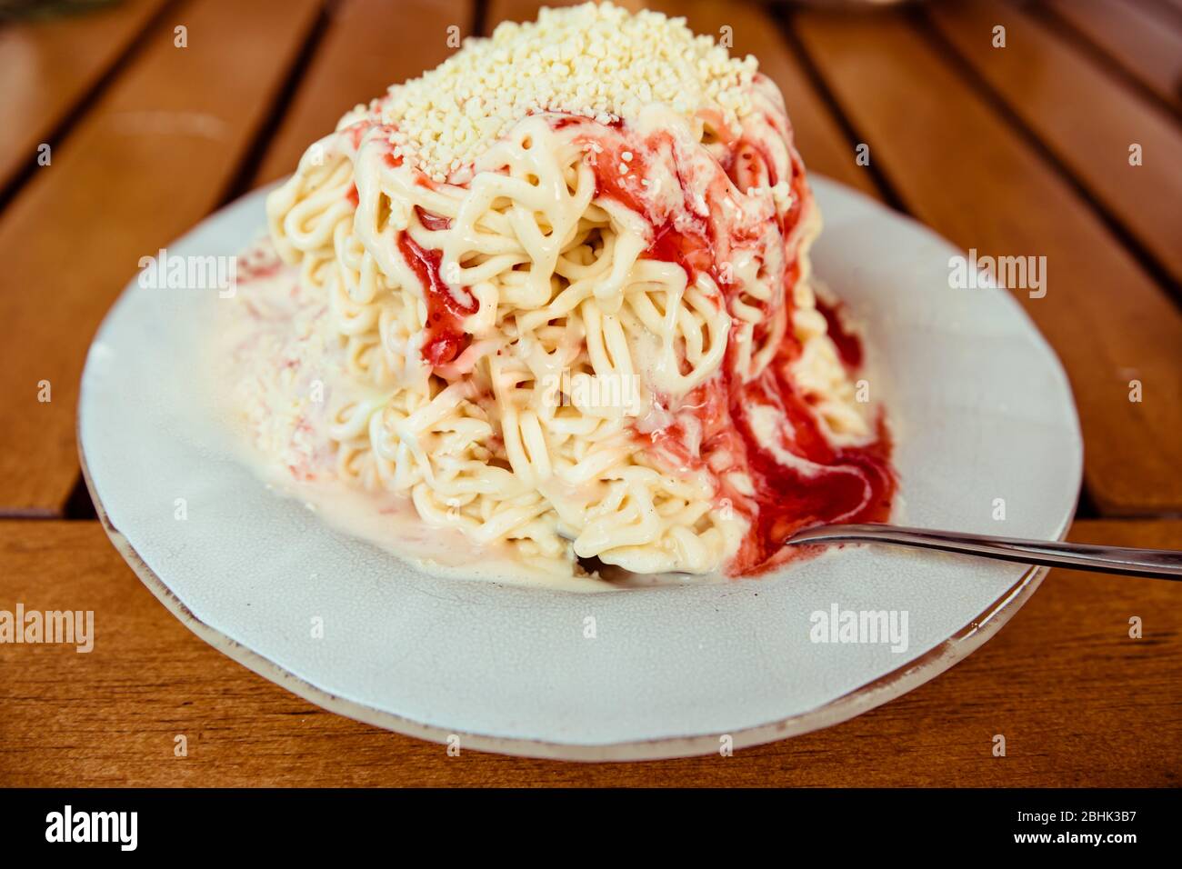 Una porzione dello spaghettieis tedesco di novità - gelato alla vaniglia e sambuco di fragola come un'illusione di spaghetti Foto Stock