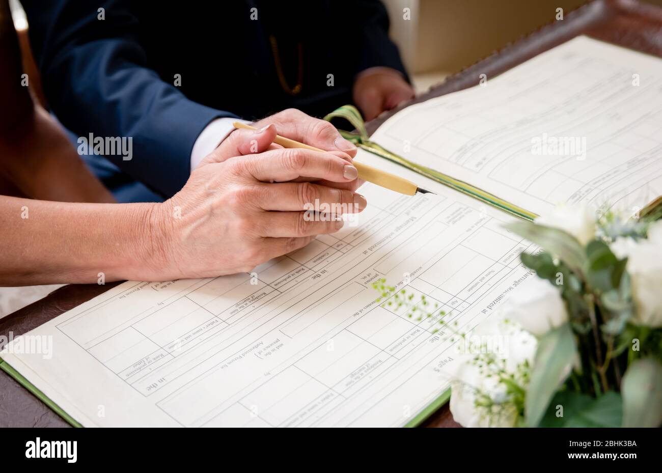 Una coppia più anziana ottiene sposata e firma il libro di registro di nozze Foto Stock