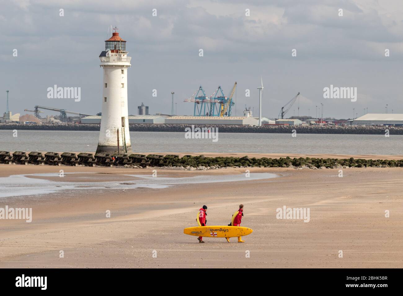 Bagnini con tavola da surf sulla spiaggia, New Brighton, Merseyside Foto Stock