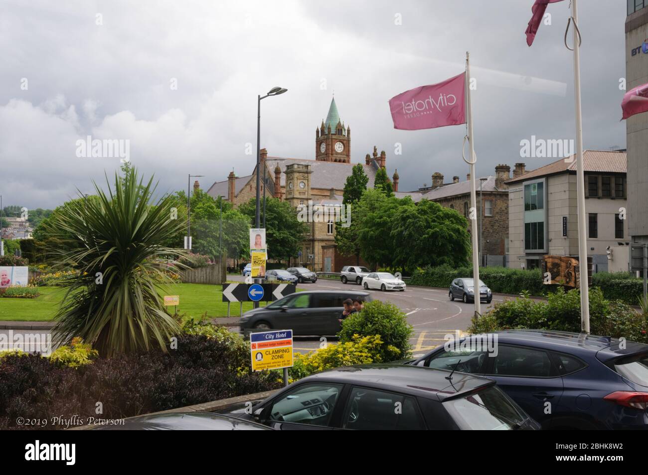Londonderry, Irlanda del Nord, UK/May17, 2019: Circolo del traffico con auto e una chiesa che si assalica sullo sfondo di Londonderry, alias Derry a Norther Foto Stock