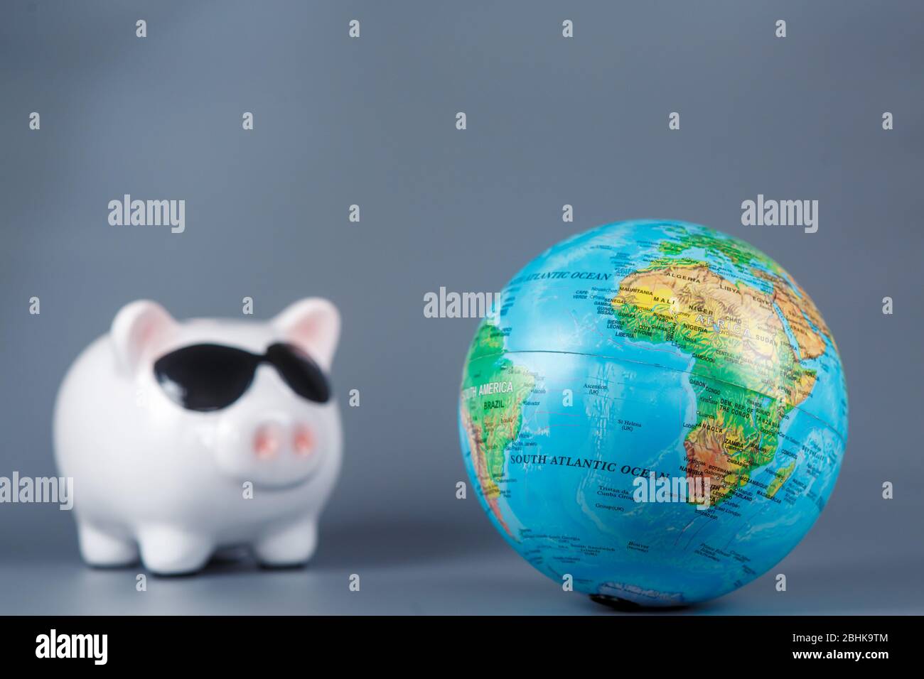 Pig Piggy banca con un globo su uno sfondo grigio Foto Stock