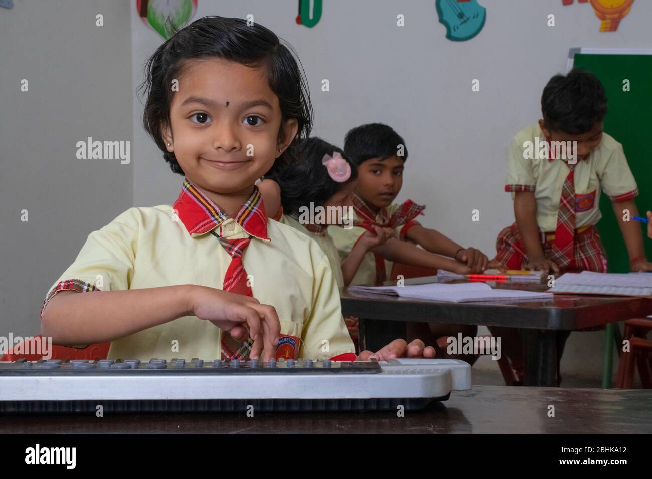 Scuola elementare che suona lo strumento musicale in classe scolastica Foto Stock