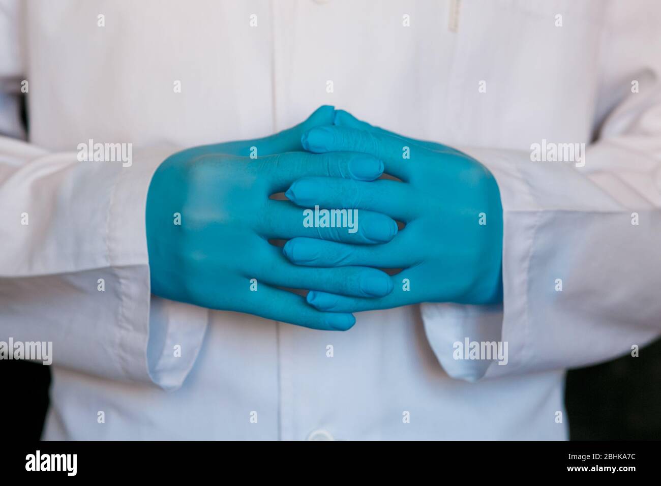 primo piano del medico. Guanti medici del chirurgo su sfondo nero. Foto Stock