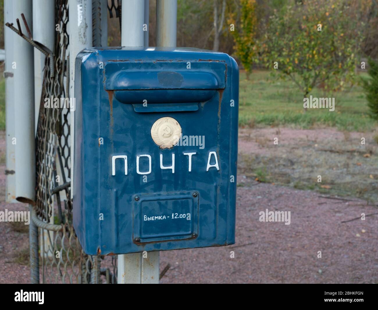Vecchia cassetta postale nel complesso commemorativo nella zona di esclusione di Cernobyl. Testo sulla casella: Posta e presa in uscita alle 12:00. Cernobyl, Ucraina Foto Stock