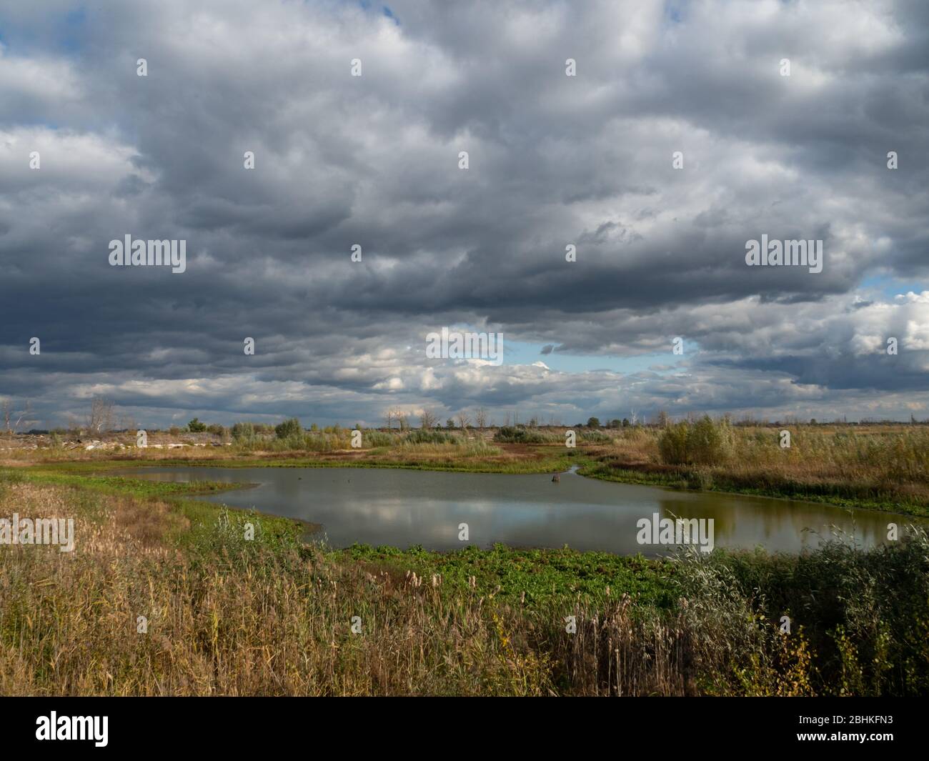 Rottami e residui di allevamento di pescatori nella zona di esclusione di Cernobyl, Ucraina. Cielo spettacolare sul lago. Foto Stock