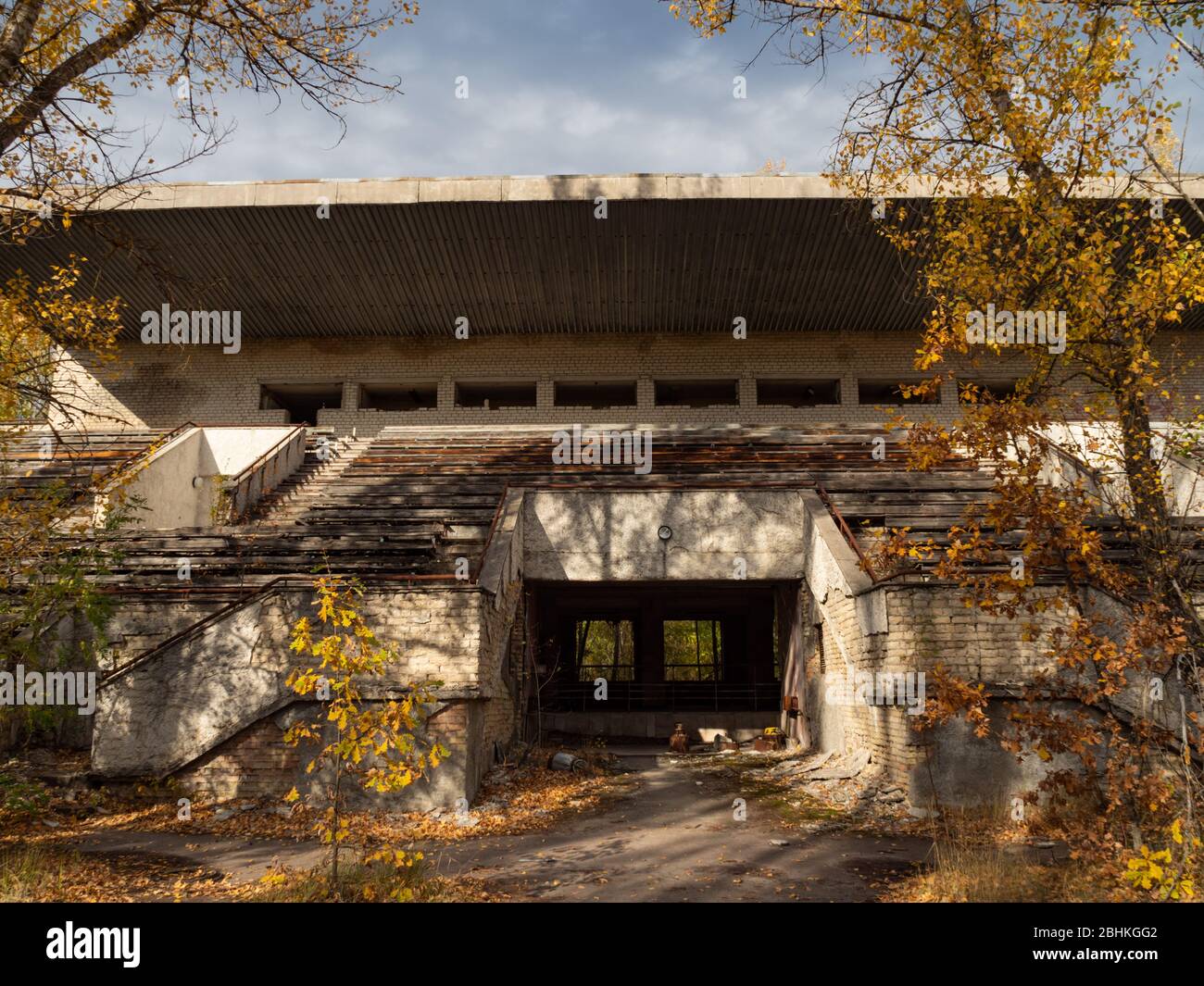 Tribuna abbandonata dello stadio Avangard, presa dalla natura nella città fantasma Pripyat nella zona di esclusione di Chernobyl. Ucraina Foto Stock