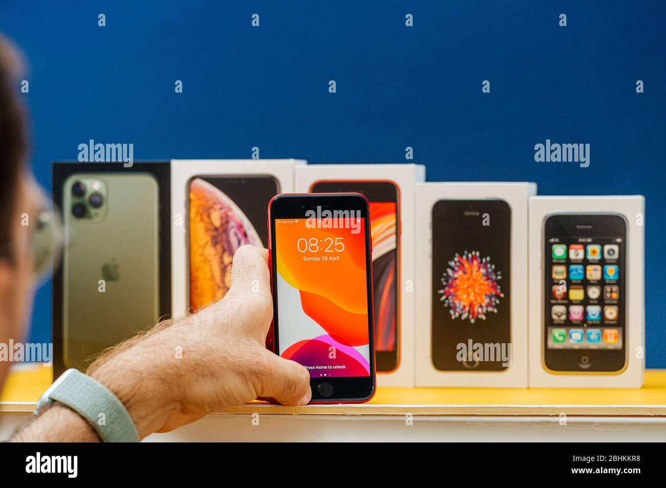 Parigi, Francia - 26 aprile 2020: Uomo che aggiunge l'ultima scatola se 2020 a più pacchetti schede di Apple computer iPhone smartphpone iPhone 3gs, se 2016, XS e 11 Pro Foto Stock