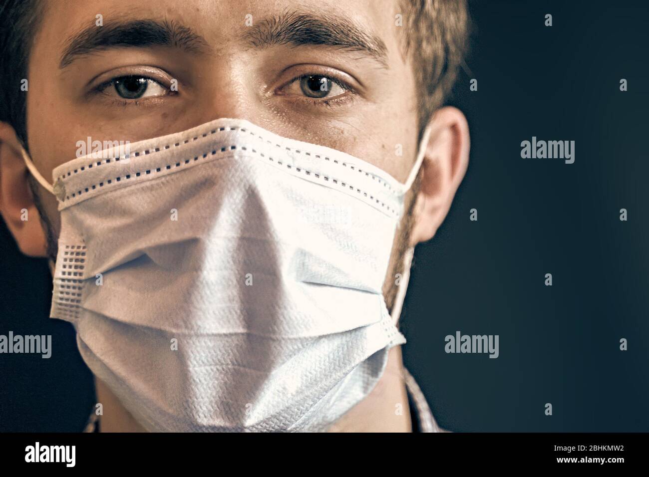 Uomo che indossa una maschera igienica per prevenire le infezioni. Foto Stock