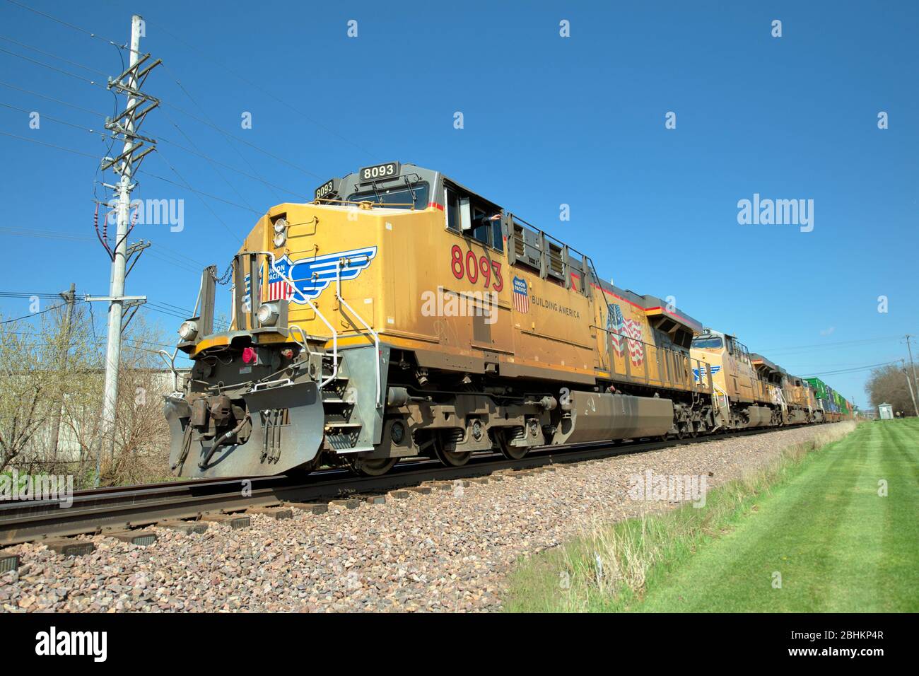 Ginevra, Illinois, Stati Uniti. Quattro locomotive che conducono un treno merci di auto impilate o container in un viaggio verso ovest da Chicago. La linea multi-traccia li Foto Stock
