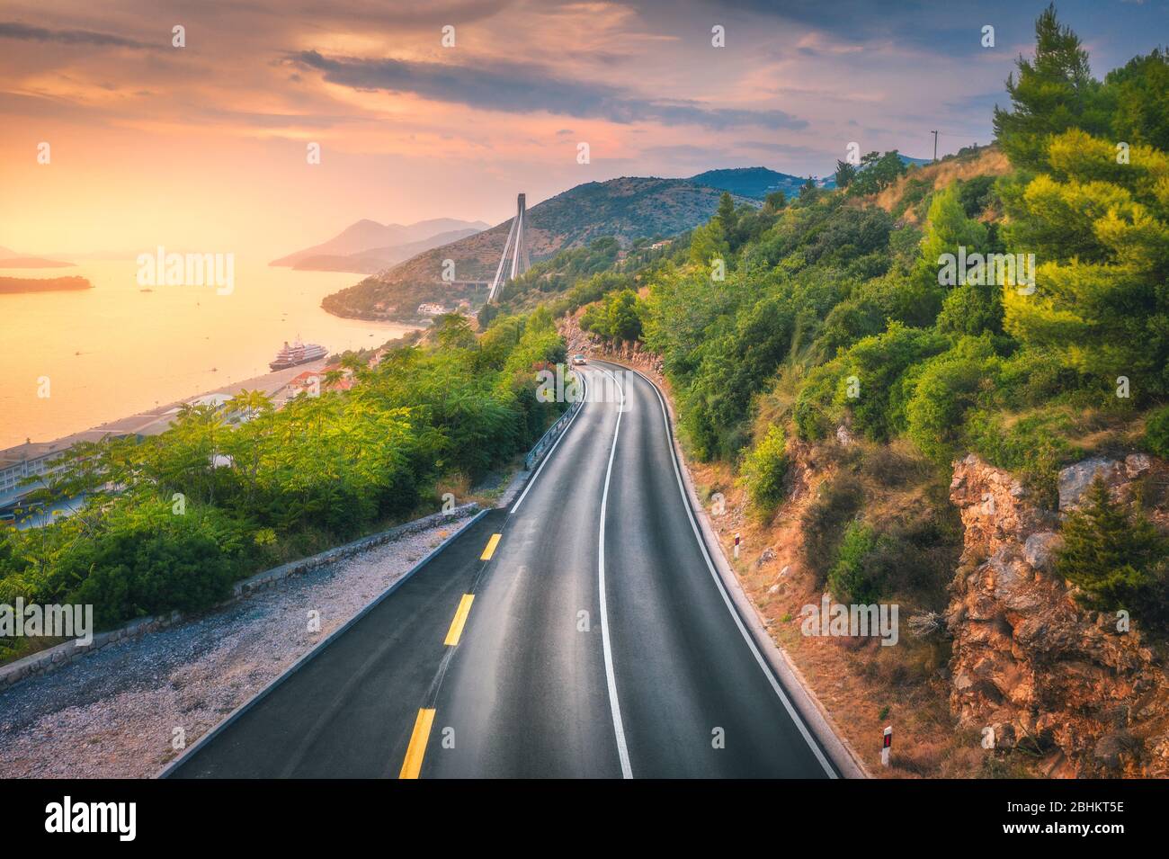 Vista aerea di una perfetta strada di montagna e di una bellissima foresta verde Foto Stock