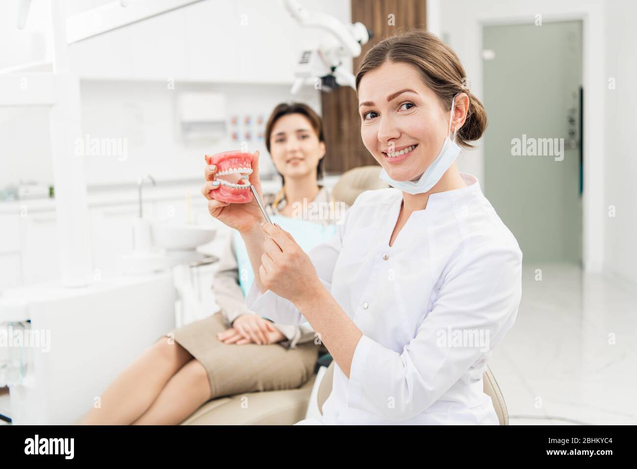 Un sorriso sano e bello. Ritratto di un medico che regge una mascella artificiale con un apparecchio ortodontico. Foto Stock