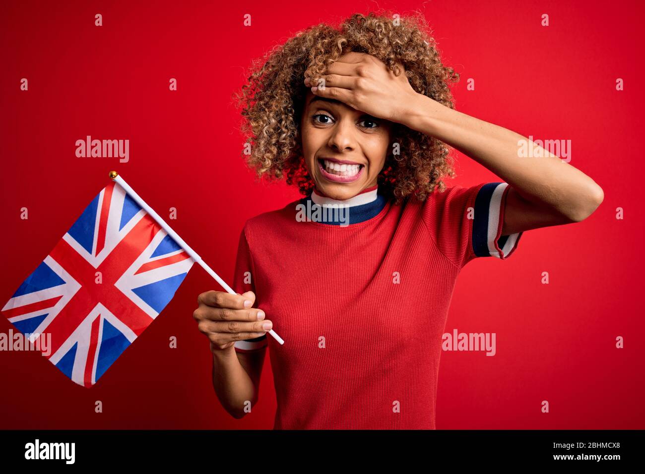 La giovane maledetta africana americana che tiene la bandiera del regno unito in occasione del referendum sulla brexit ha sottolineato con la mano sulla testa, scioccata dalla vergogna e dalla sorpresa faccia, ang Foto Stock
