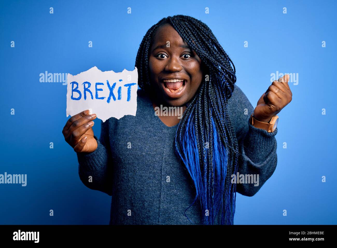 Giovane african american Plus donna con le trecce che tengono carta con il messaggio brexit che urla orgoglioso e celebra la vittoria e il successo molto eccitato, Foto Stock
