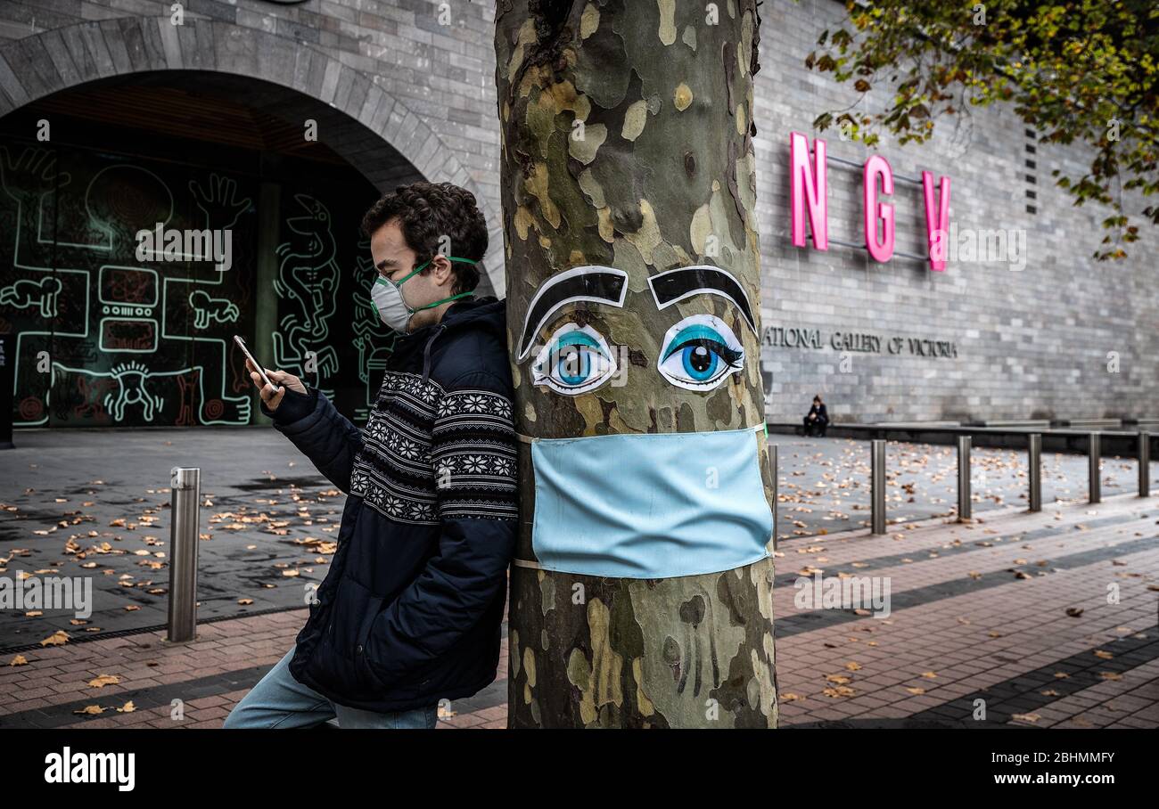 Covid-19 Pandemic Melbourne Australia 2020. Maschera chirurgica facciale su un albero fuori dalla Galleria Nazionale di Victoria a Melbourne. Foto Stock
