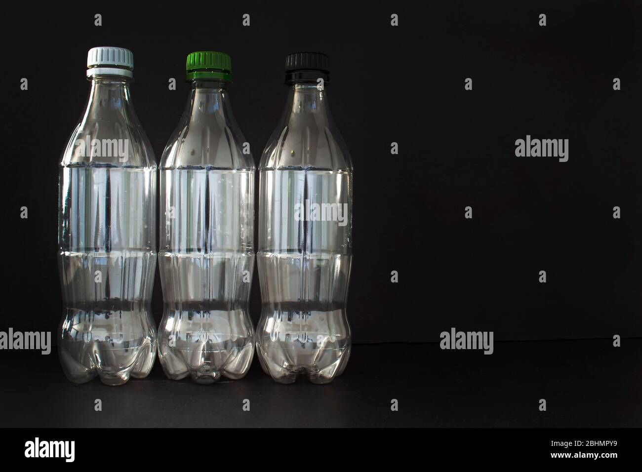 Bottiglie di plastica vuote per bibite su sfondo nero Foto Stock