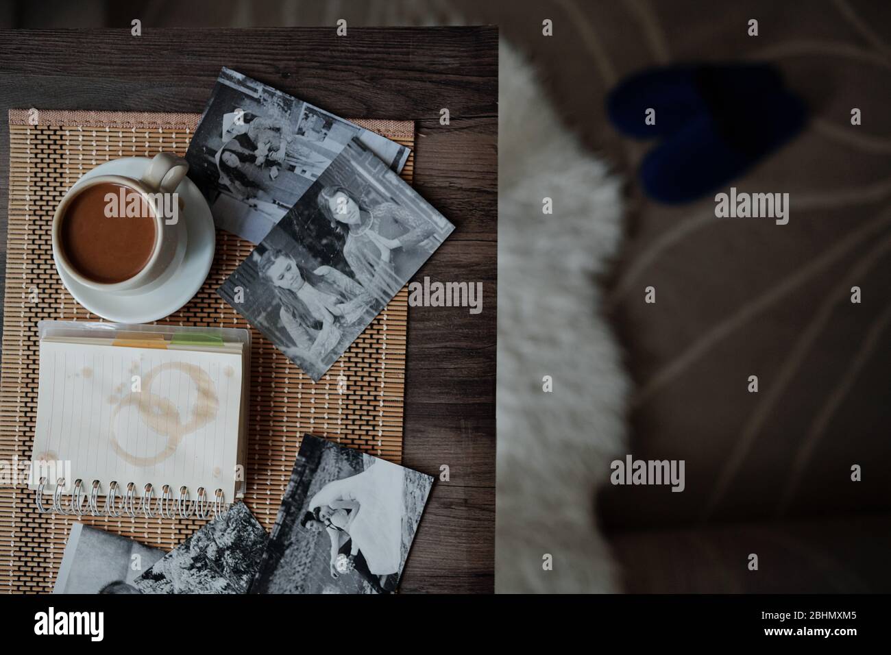 Tazza di cappuccino, pianificatore con macchie di caffè e foto stampate in bianco e nero su tavolo del fotografo Foto Stock