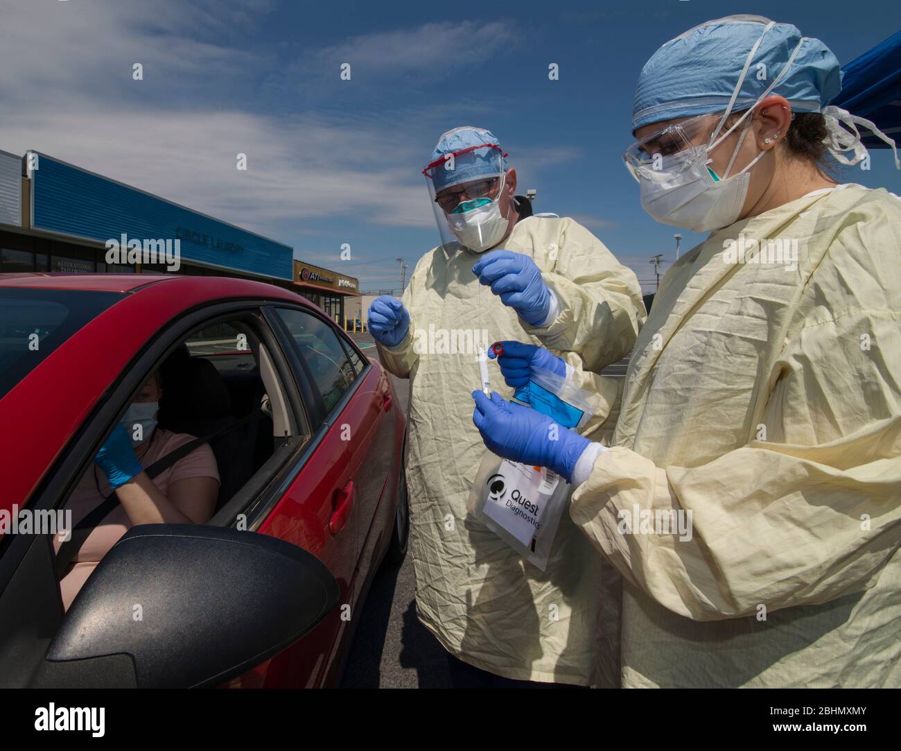 Guidare attraverso i test COVID-19, Medford, Massachusetts, USA. 25 aprile 2020. Tecnico medico che posiziona il tampone nasale nella provetta presso PhysicianOne urgent Care. Foto Stock