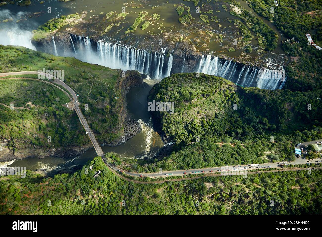 Cascate Vittoria o 'mosi-oa-Tunya' (il fumo che Thunders), fiume Zambesi, e Victoria Falls Bridge, Zimbabwe / confine con Zambia, Africa Meridionale - aer Foto Stock